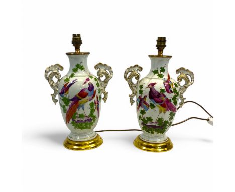 A pair of Chelsea style porcelain table lamp bases, each with elaborate scrolling twin handles and painted with exotic birds 