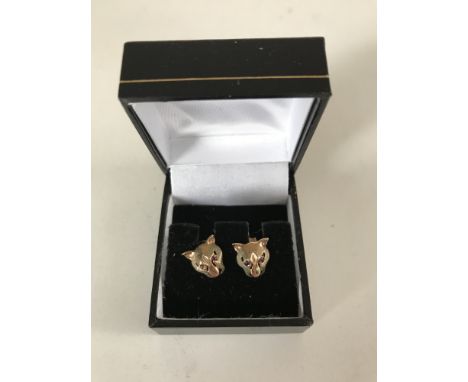 A pair of 9ct gold lioness earrings with ruby set eyes, 2.0g