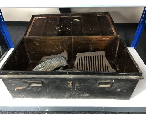 An early 20th century tin trunk containing metal fire grates