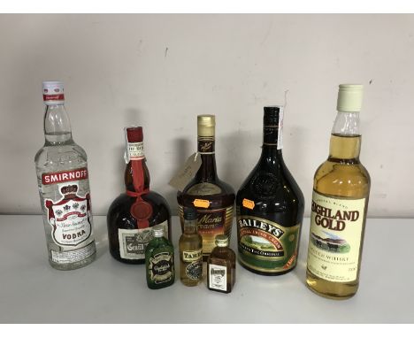 A tray containing alcohol including Smirnoff vodka, Bailey's, High Gold Scotch Whisky, Tia Maria and Grand Marnier, three alc