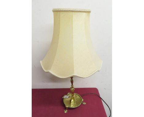 Brass table lamp, on turned column with circular dished base on three pad feet 