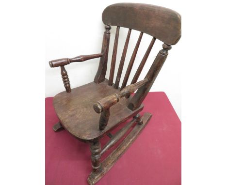 Child's stained beech Windsor type rocking chair with stick back and turned supports on curved stretchers 