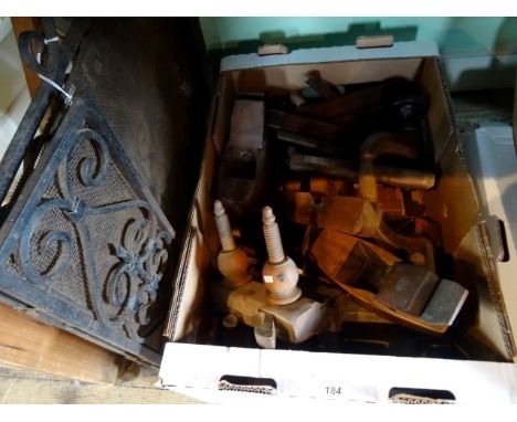 A box containing wooden planes and tools, together with a metal fireguard.