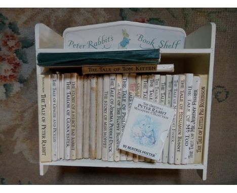 A child's book shelf, containing a quantity of Peter Rabbit and related story books.