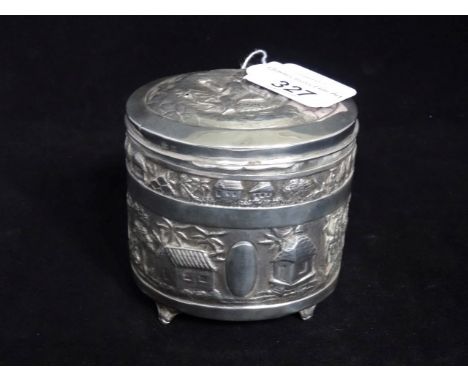 An early 20th century silver tea caddy of oval form, decorated with Indian pastoral scenes on four squat supports, Birmingham