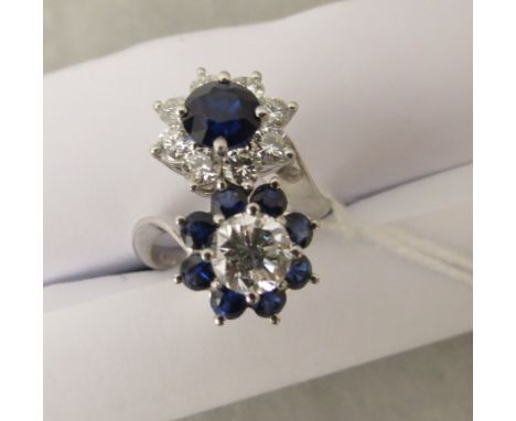 A Kutchinsky vintage 18ct white gold cross over cluster ring set with fine sapphires and diamonds