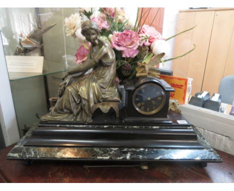 A 19th century large French black slate and green marble mantel clock mounted with a Grecian female over a step plinth base