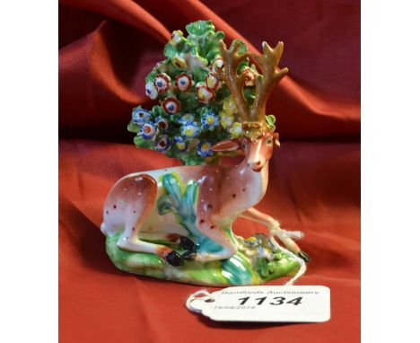 A Derby Patch Mark model, recumbent stag, before bocage, coloured in tan, the bocage encrusted with flowers, incised 3, 19cm 