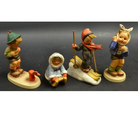 A Goebel figure, boy with toothache, others including skiing; sledging etc (4) 