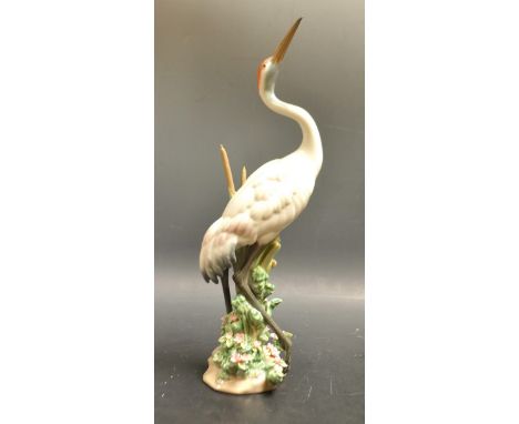 A Lladro figure of a crane, decorated with applied flowers