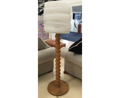 A modern spiral wooden lamp with white shade