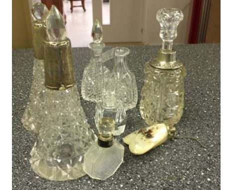 A quantity of vintage glass and crystal perfume bottles, some with silver rims