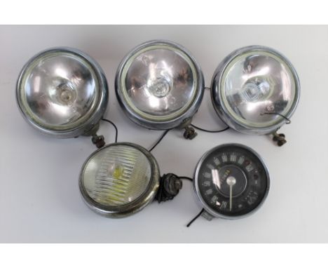 Three Cibie Oscar Iode SAE 03 headlights, a vintage Smith's speedometer, and a Bosch 1157 headlight