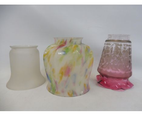 An Edwardian cranberry coloured glass lamp shade and two others.