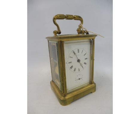 A brass carriage clock with secondary dial and repeater, keys attached.