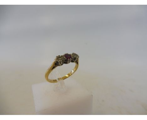 An 18ct gold and platinum ring, set with a central ruby, flanked by two diamonds, size M, 3g.