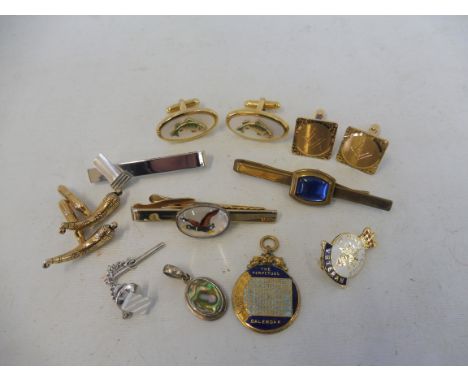 An enamel perpetual calendar pendant and various cufflinks, brooches etc.