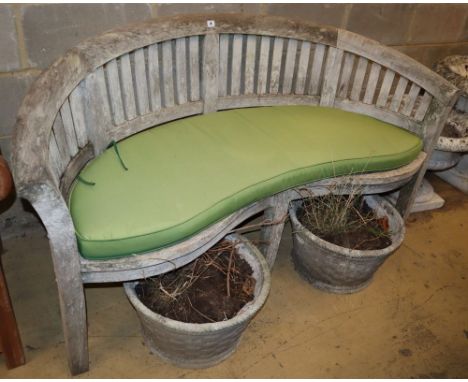 A weathered teak garden banana bench with cushion, W.160cm, D.60cm, H.85cm