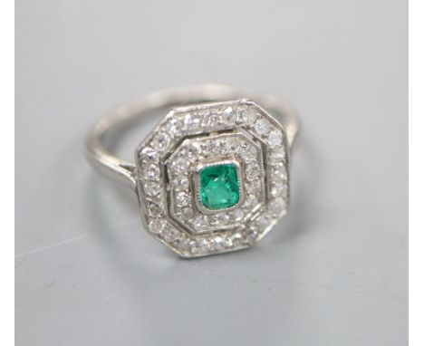 An Art Deco white metal, emerald and diamond set octagonal tablet ring, (emerald chipped), size J/K, gross 3.4 grams.