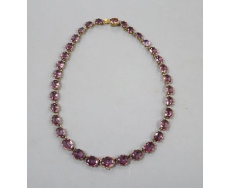 A Victorian pinchbeck and graduated amethyst coloured paste set necklace, 45.2cm, lacking central drop.
