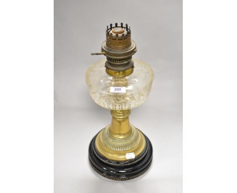 An early 20th Century Young's brass oil lamp, having a cut glass reservoir, and on a stepped ebonised base, measuring 41cm ta