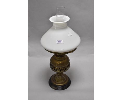 A Victorian pierced brass oil lamp, with conical glass shade, 51cm tall, together with four mantel clocks of various ages and