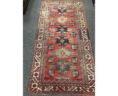 VINTAGE KARADJA NARROW RUG, Persia, six hooked medallions on a madder field interspersed with octagonal guls, serrated leaves