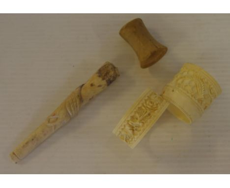 Four assorted antique carved ivory pieces to include a pipe and napkin ring