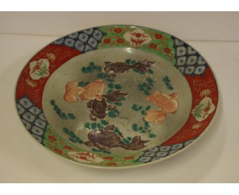 Early Japanese ceramic charger decorated with swimming fish, 34cm diameter approx