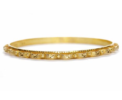 EIGHTEEN CARAT GOLD BANGLE with a scalloped openwork border, 70mm to the outer edge, 18.5g