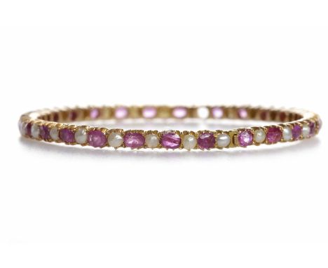 EARLY TWENTIETH CENTURY CREATED RUBY AND SPLIT PEARL BANGLEof hinged form, set with oval created pink rubies 3.5mm long and i