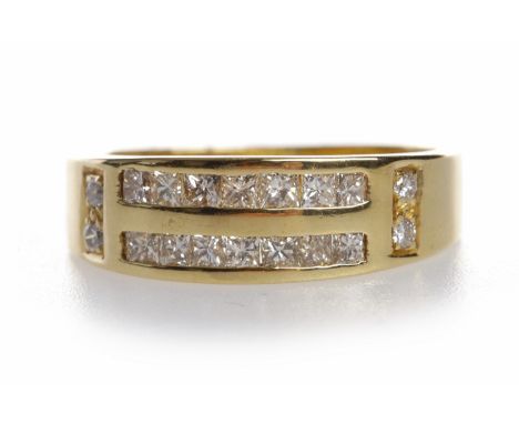 DIAMOND DRESS RINGthe broad band set with two rows of princess cut diamonds totalling approximately 0.14 carats, with two rou