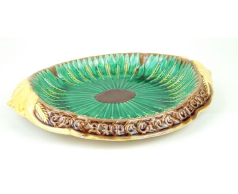 A Victorian Majolica bread plateOf oval form relief decorated with corn sheaves, with verse 'The appetite Obeys Where Reasons