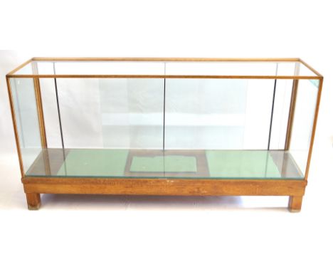 A vintage glazed light oak shop counterThe traditional rectangular form, with rear sliding glass doors, raised on block suppo
