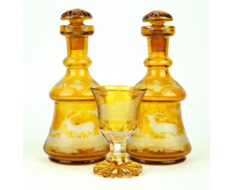 A pair of Bohemian amber glass decanters Each having engraved decoration of stags in landscape, with star cut stoppers, heigh