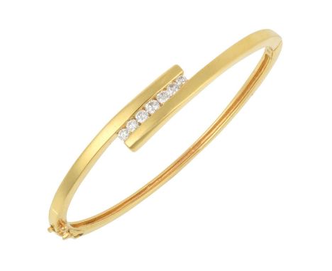 An 18 Carat Gold Diamond Banglethe yellow crossover motif with seven round brilliant cut diamonds centrally, in tension setti