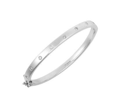 A 9 Carat White Gold Diamond Hinged Bangle inset with eight round brilliant cut diamonds, to a plain polished hinged back, to
