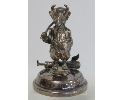 A "Lucifer Golfing Society" plated car mascot depicting a devil in plus fours smoking a pipe, with golf club swung over one s