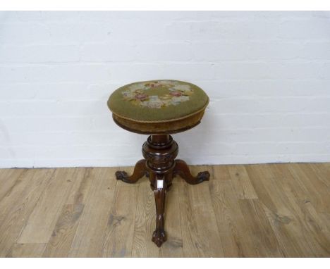 Victorian rosewood piano stool, the circular revolving tapestry top on turned baluster column and carved tripod supports with