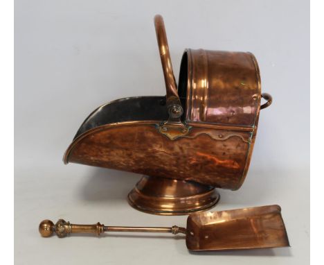 Copper coal scuttle of helmet form with fixed and swing handle, 43cm long, also a copper shovel. (2). 