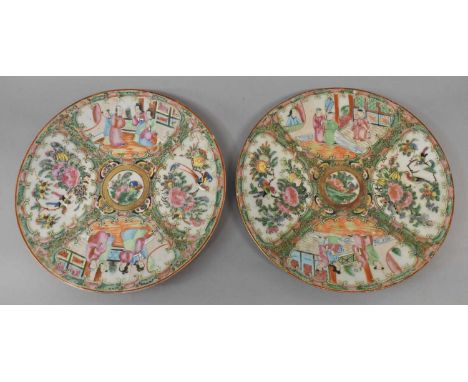A pair of late 19th century Chinese Canton Famille Rose plates each decorated with four panels within a butterfly and scroll 