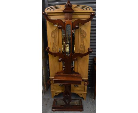 A Victorian mahogany tree-form hall stand with four scrolling branches, central mirrored section, hinged trinket box and dish