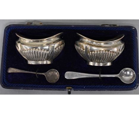 A pair of Birmingham hallmarked silver oval salts, cased with two associated spoons.