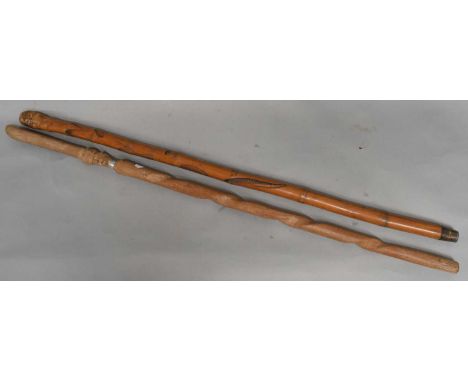 A Japanese brass tipped bamboo cane carved with fish and other animals, also an African hardwood stick (2).