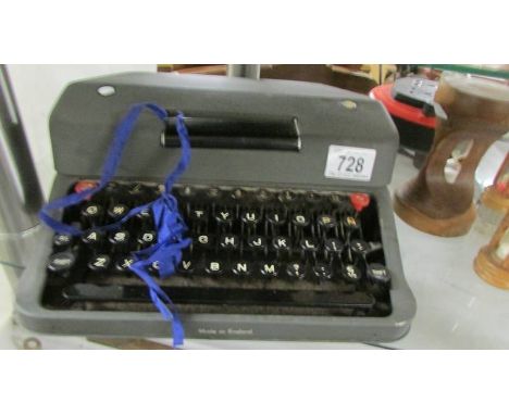 A portable typewriter (needs attention).