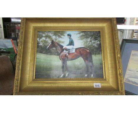 A gilt framed print of a racehorse.