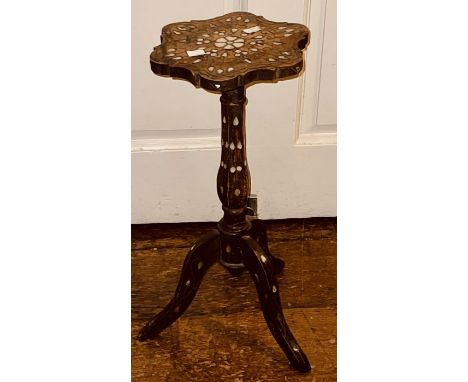 A 20th century Asian hardwood and mother of pearl lamp/wine table, foliage carved shaped top with mother of pearl, on a turne