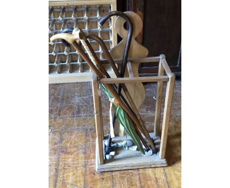 A 20th century pine stick/umbrella stand, including five sticks; including a brass handled example and a hallmarked silver on