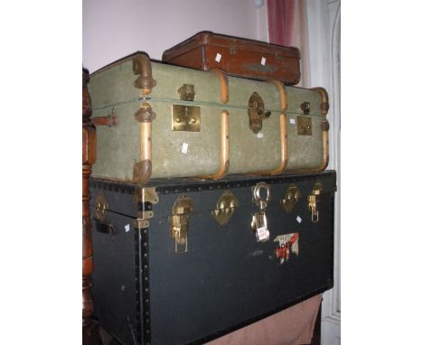 A large fabric covered travelers trunk,with 2 other suitcases.