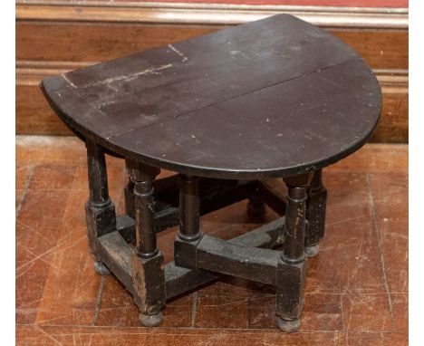 An early small oak gate leg table with an ebonised top, raised on turned supports terminating in bun feet 48cm H x 75.5cm W (